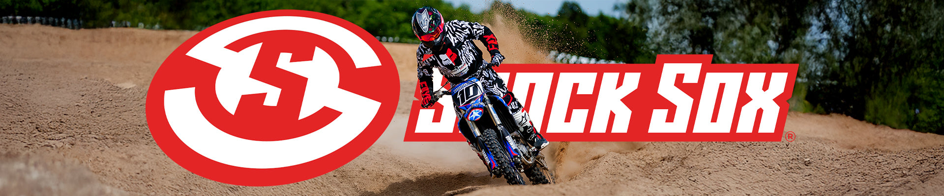 Motocross rider on a dirt track with Shock Sox logo in the background