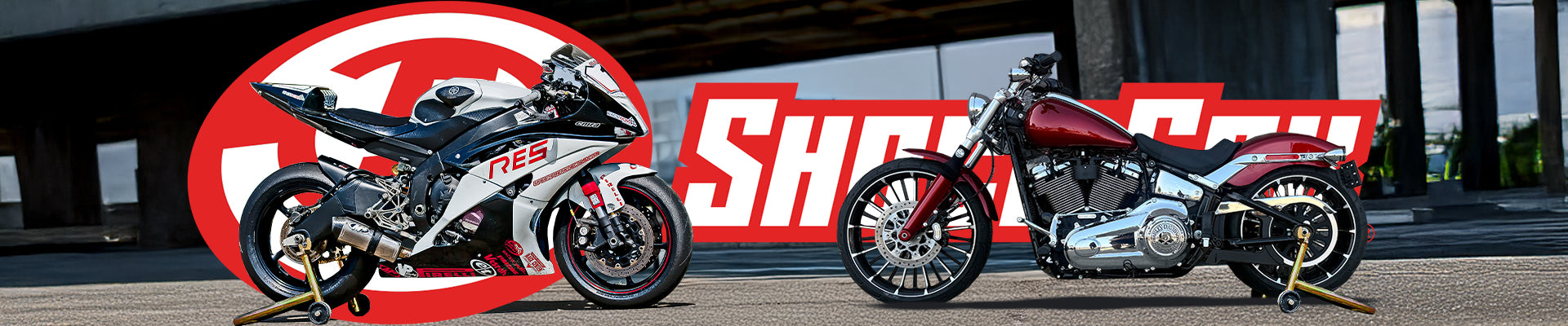 Two motorcycles parked in front of a large 'Showa' logo.