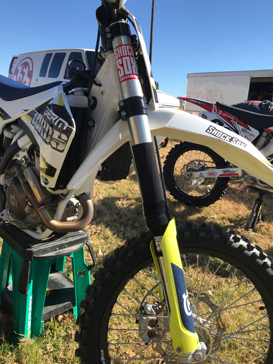 A Husqvarna dirt bike with black 13in Shock Sox on it.