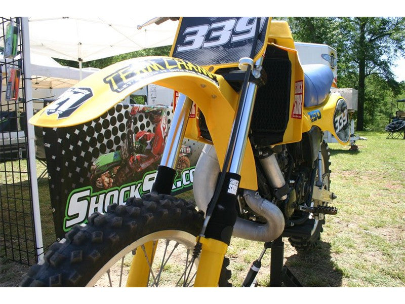 A picture of a vintage dirtbike with black Shock Sox on it.