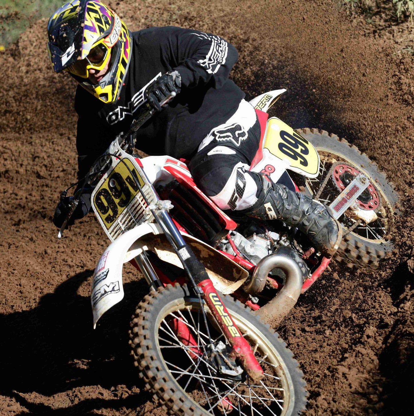 A picture of a vintage dirtbike with black Shock Sox on it.