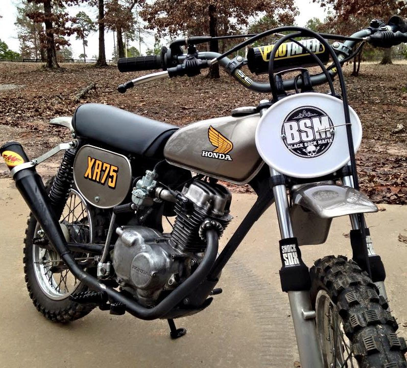 A picture of a Honda Monkey with black Shock Sox on it.