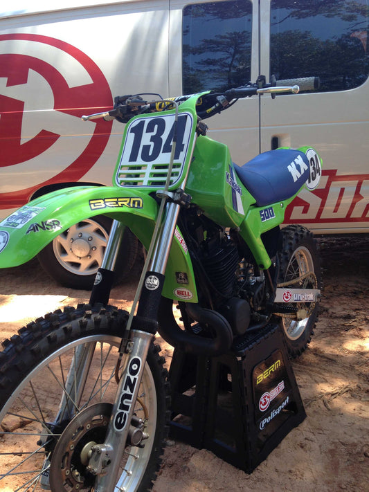 A picture of a vintage dirtbike with black Shock Sox on it.