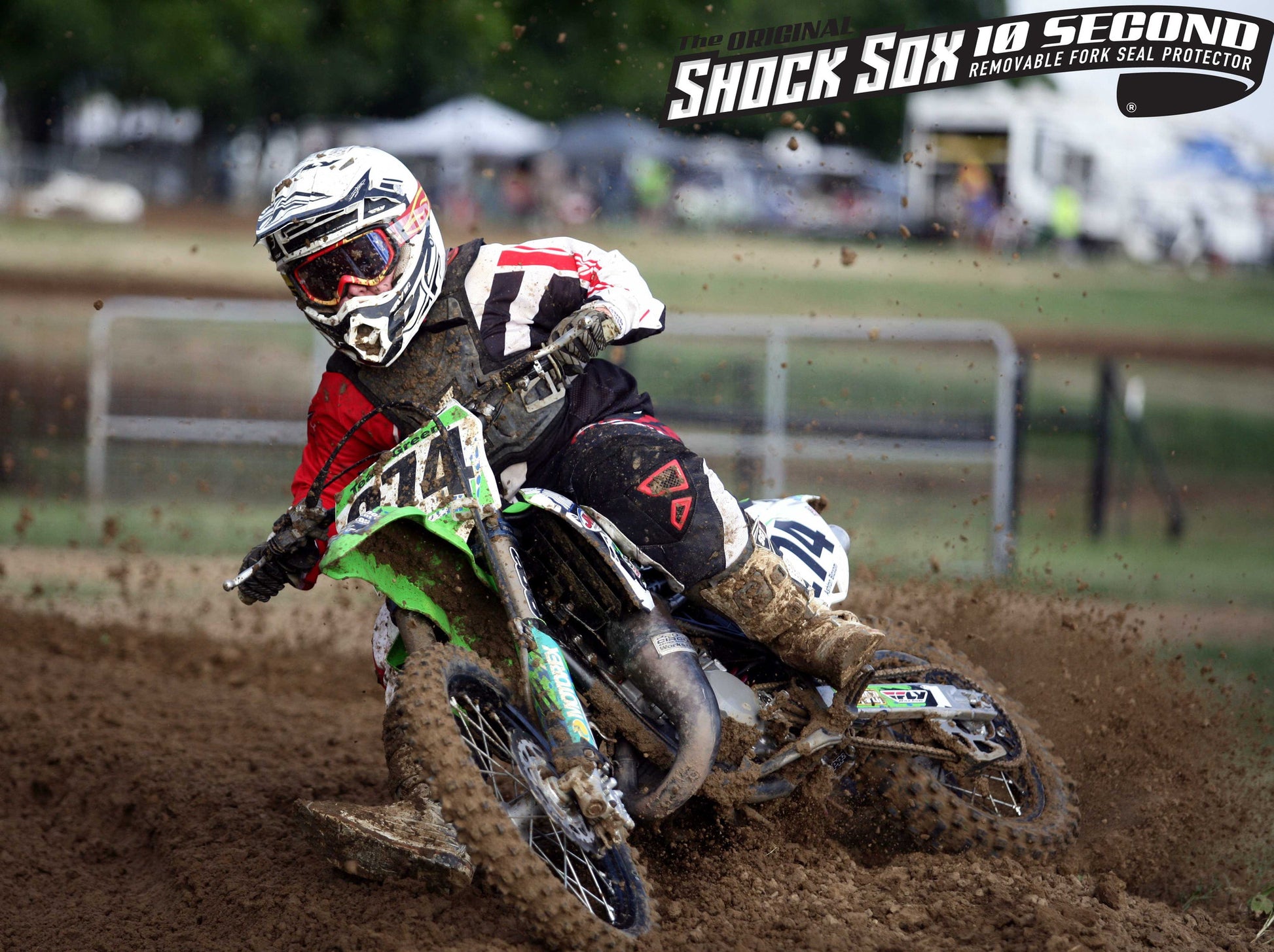 A kid riding a Kawasaki dirt bike with Shock Sox on it.