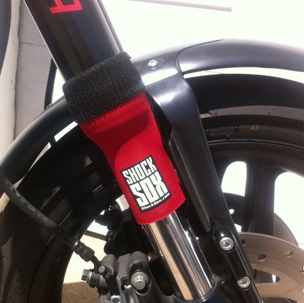 A closeup of a Harley with red Shock Sox on it.