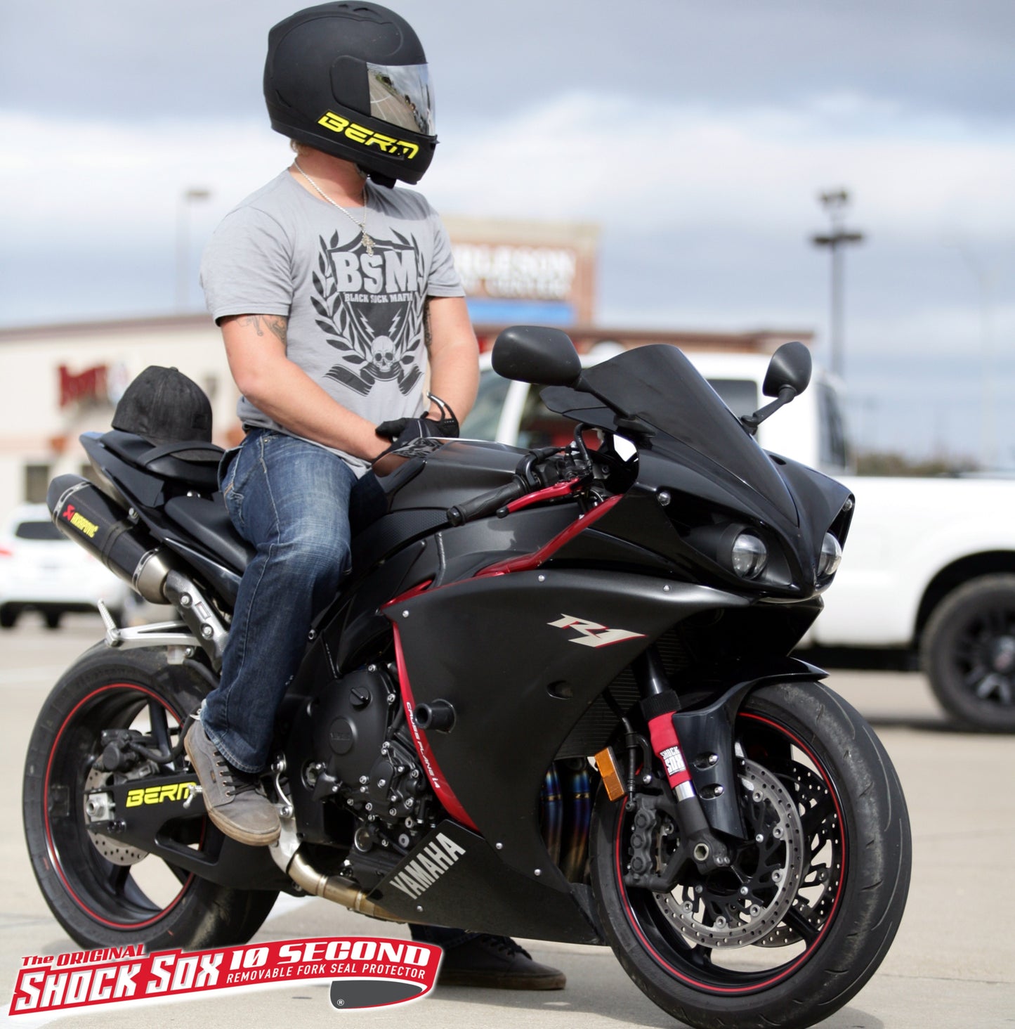 A picture of someone sitting on a street bike with red Shock Sox on it.