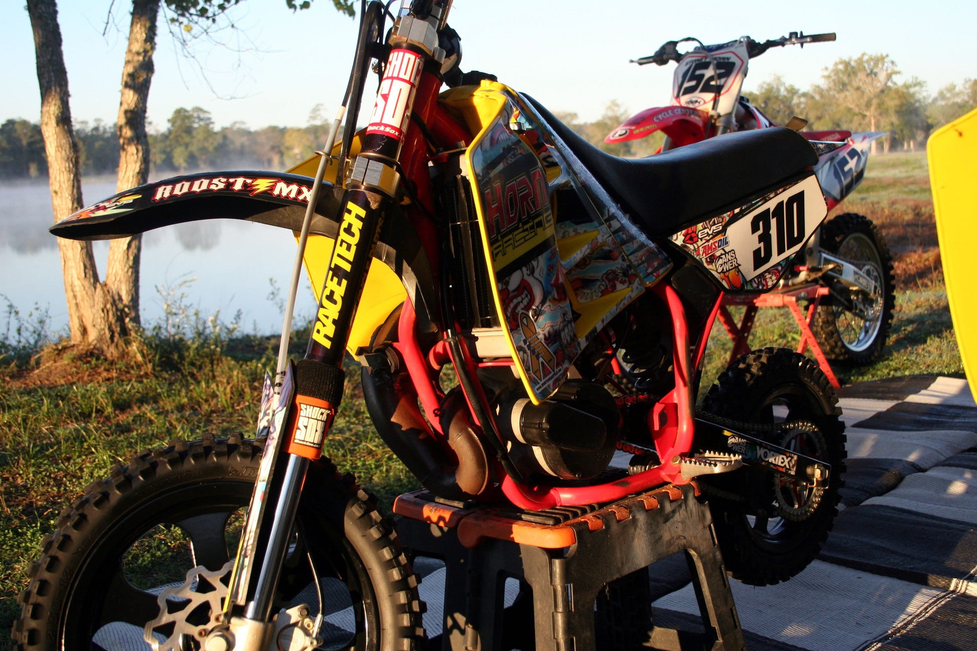 A picture of a dirt bike with orange Shock Sox on it.
