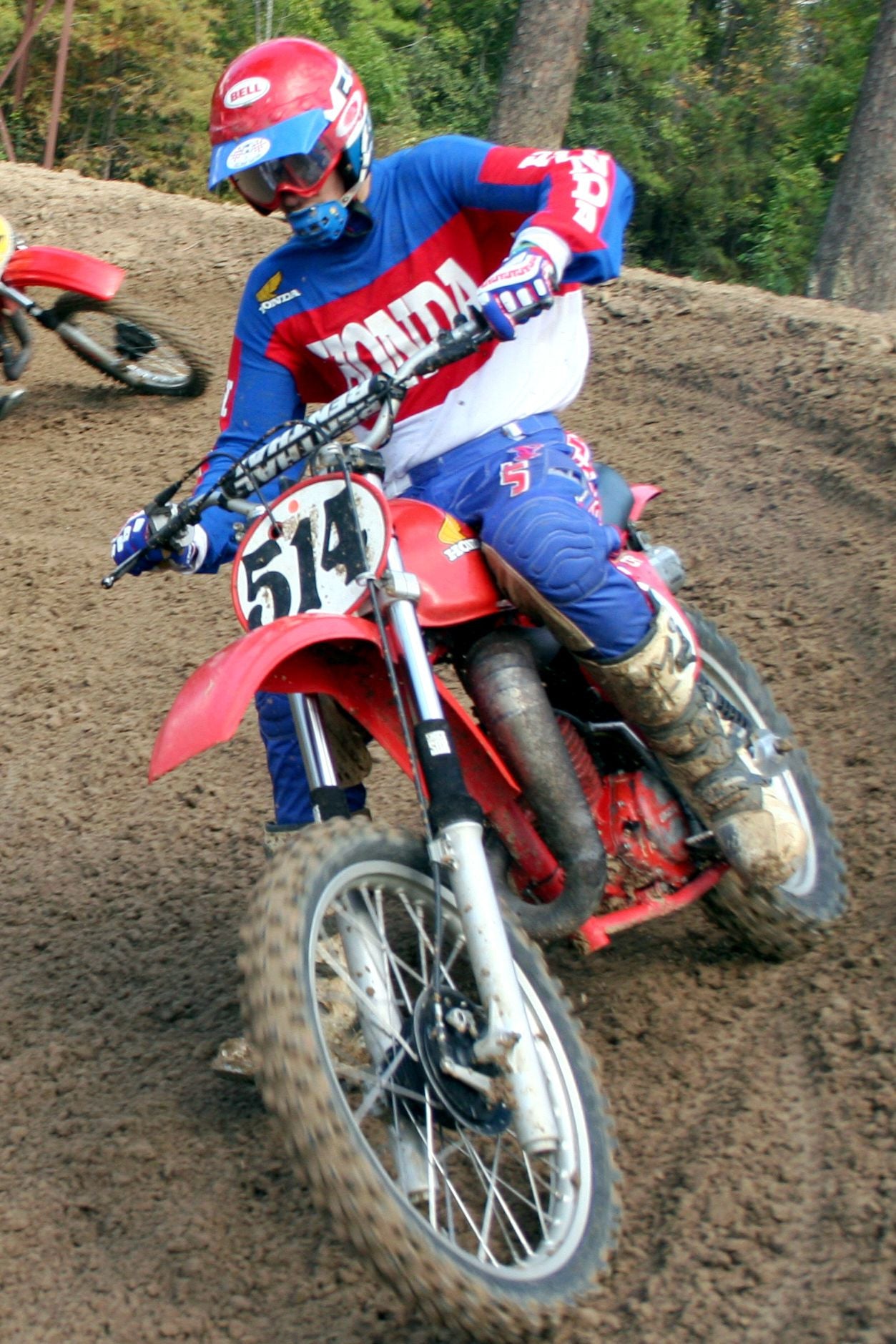 Someone riding a vintage Honda dirtbike with black Shock Sox on it.