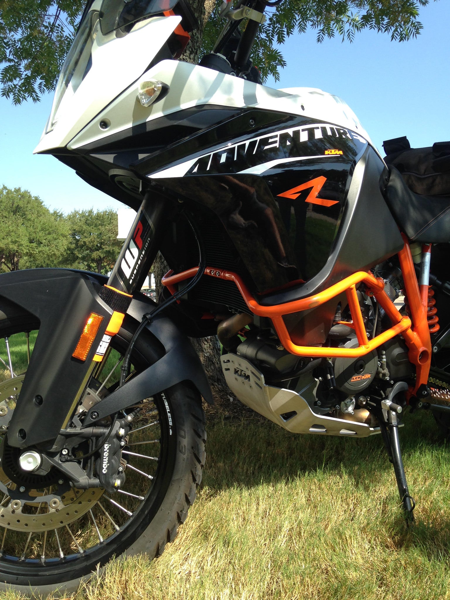 A KTM street bike with orange Shock Sox on it.