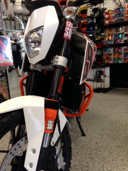 A KTM Duke with orange Shock Sox on it.