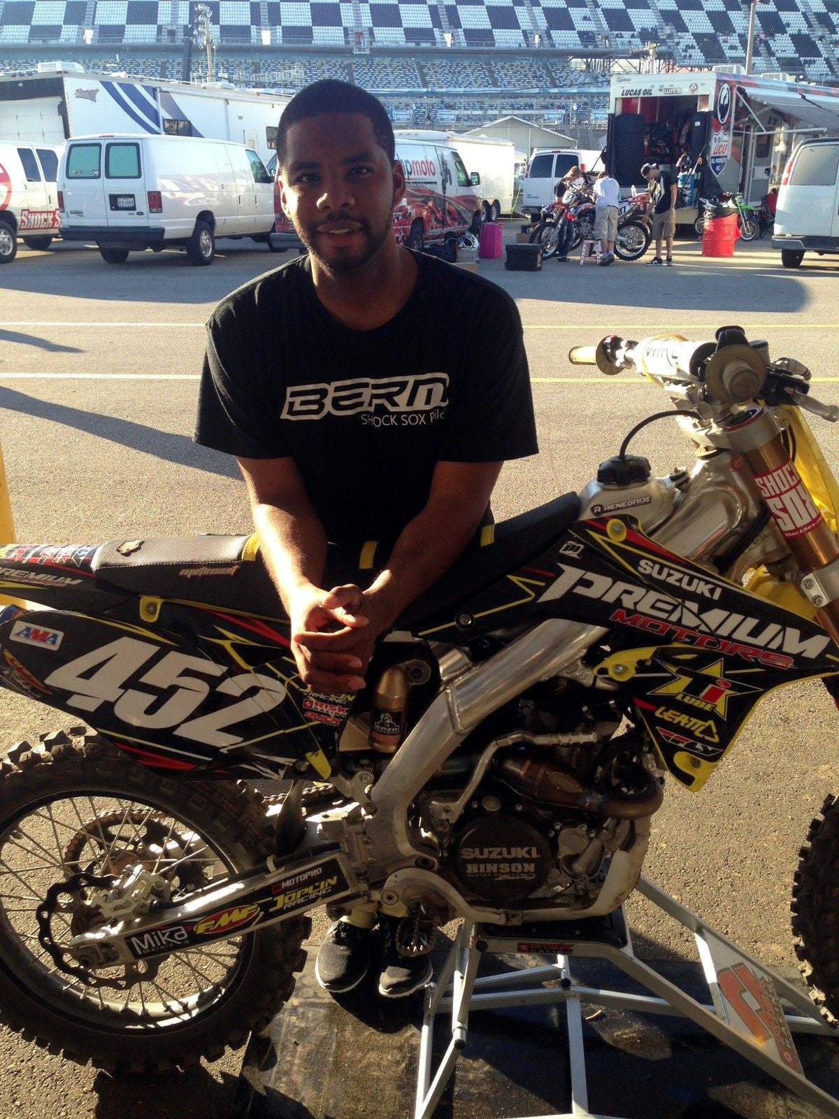 A Shock Sox sponsored rider standing behind a bike with Shock Sox on it.
