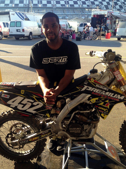 A Shock Sox sponsored rider standing behind a bike with Shock Sox on it.