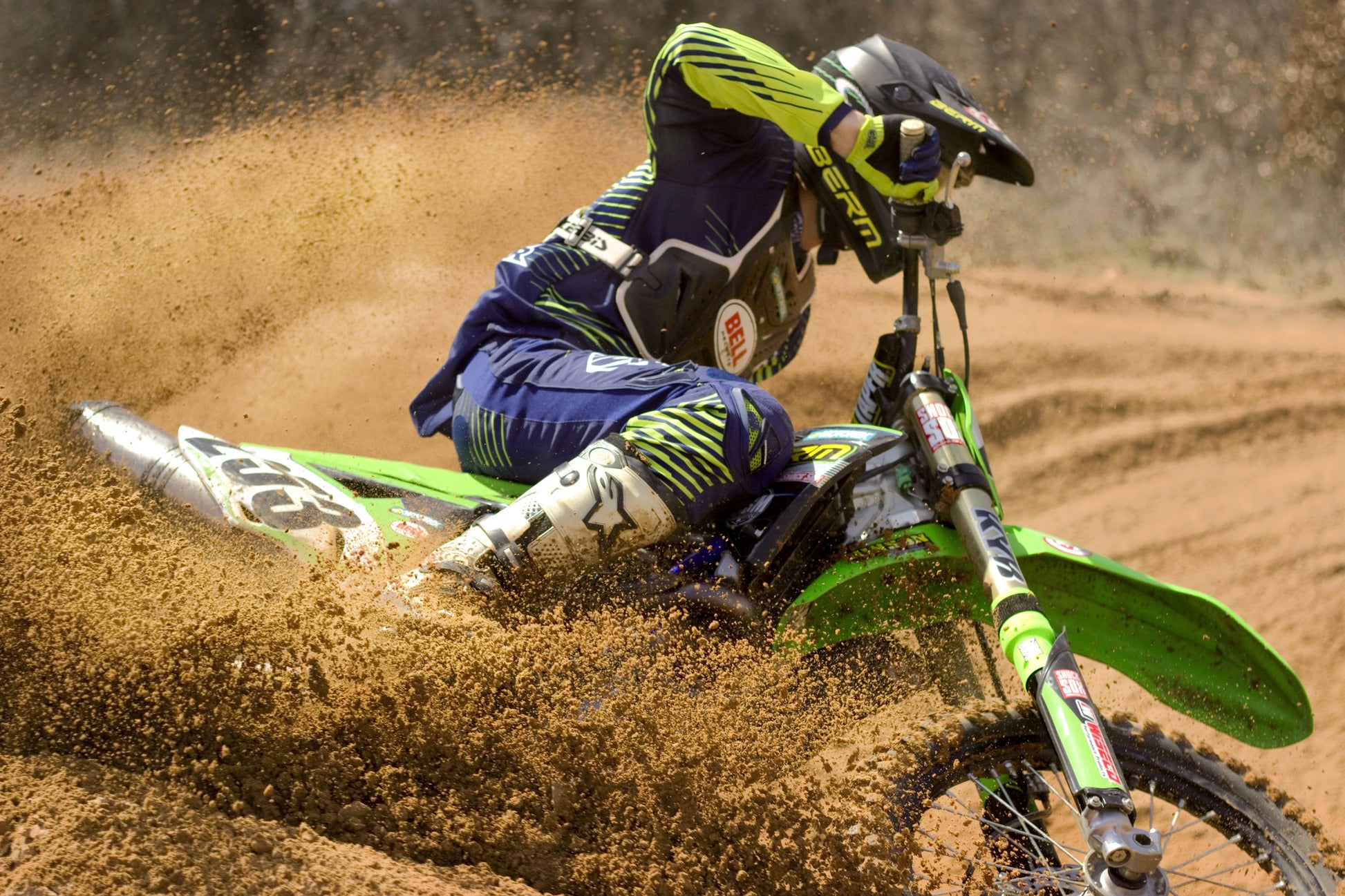 Someone riding a Kawasaki dirt bike with green Shock Sox on it.