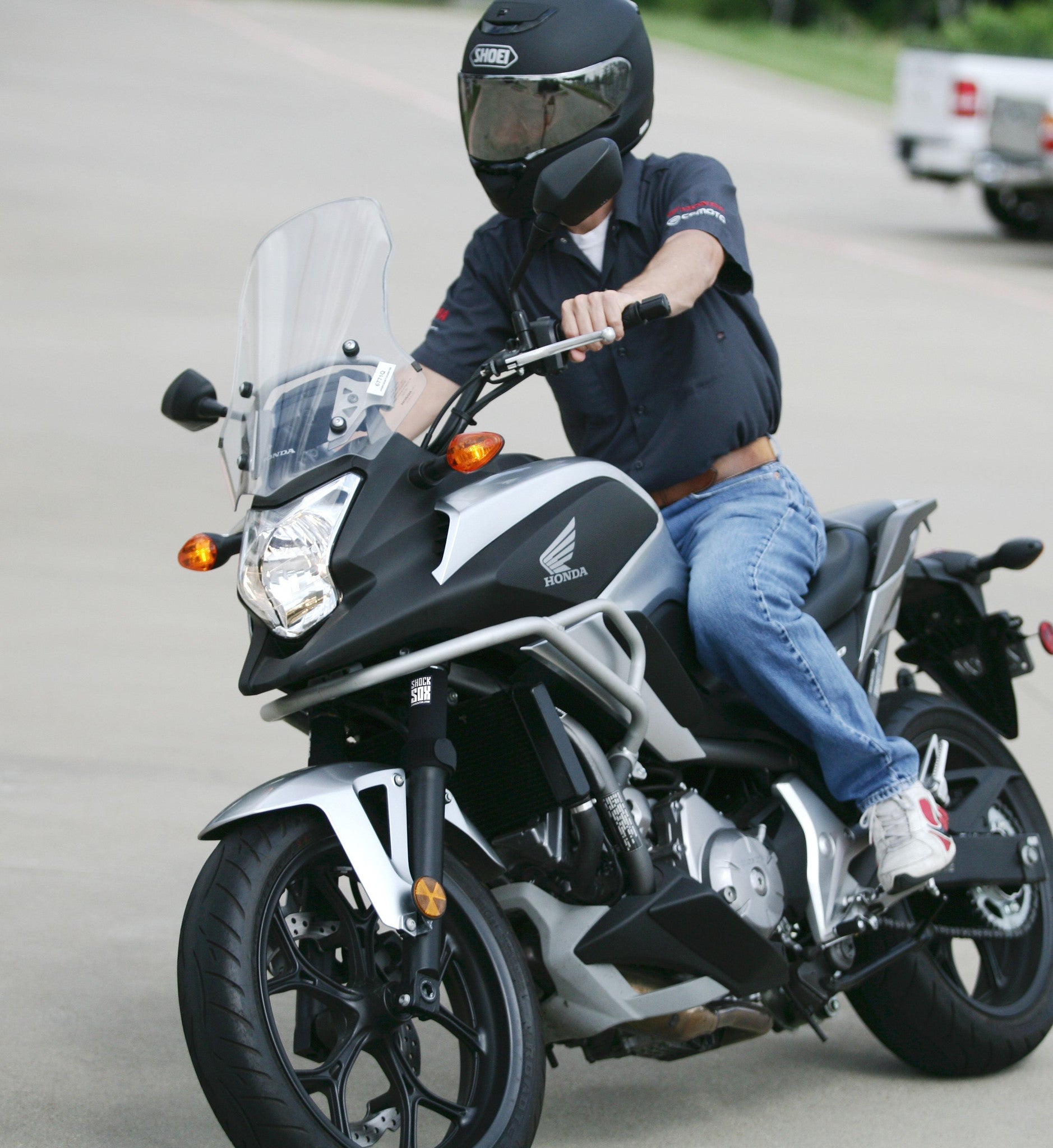 A guy riding a street bike with black Shock Sox on it.