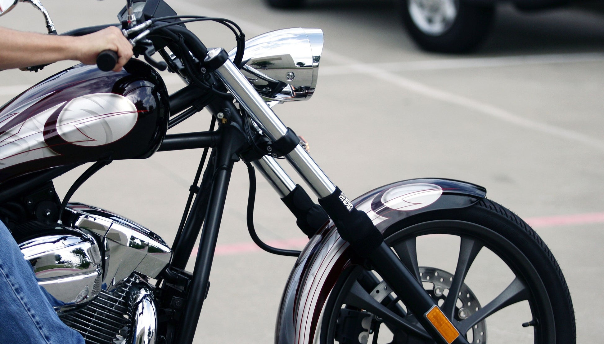 A closeup of a street bike with black Shock Sox on it