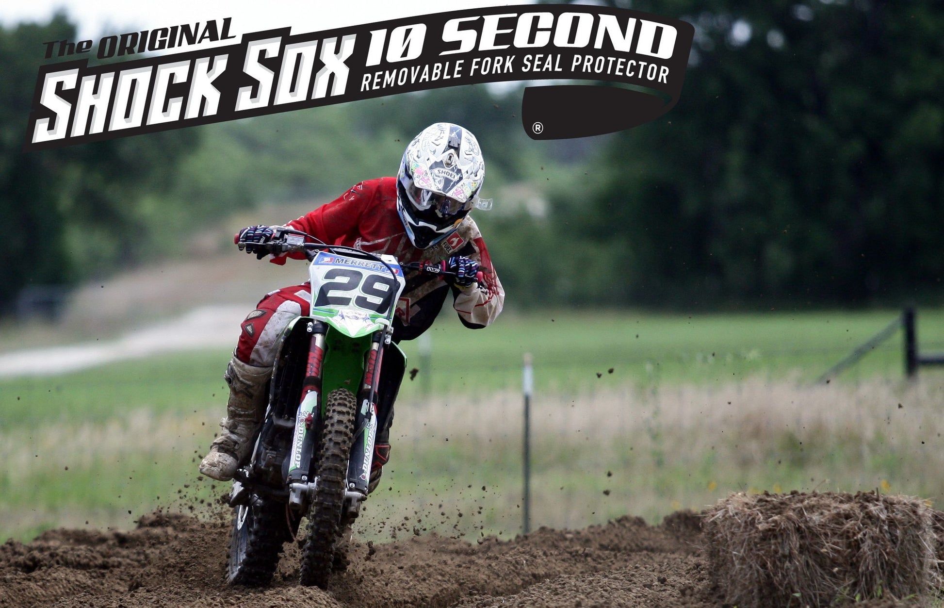 A guy riding a Kawasaki dirt bike with red Shock Sox on it.