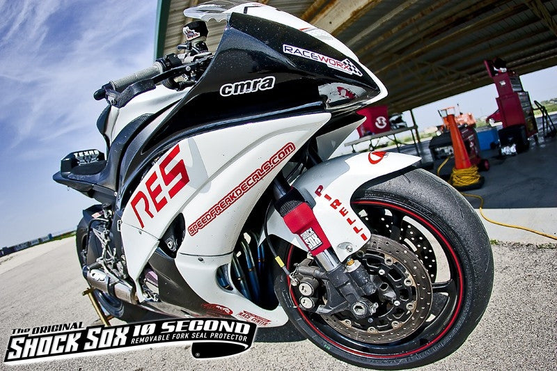 A picture of a white street bike with red Shock Sox on it.
