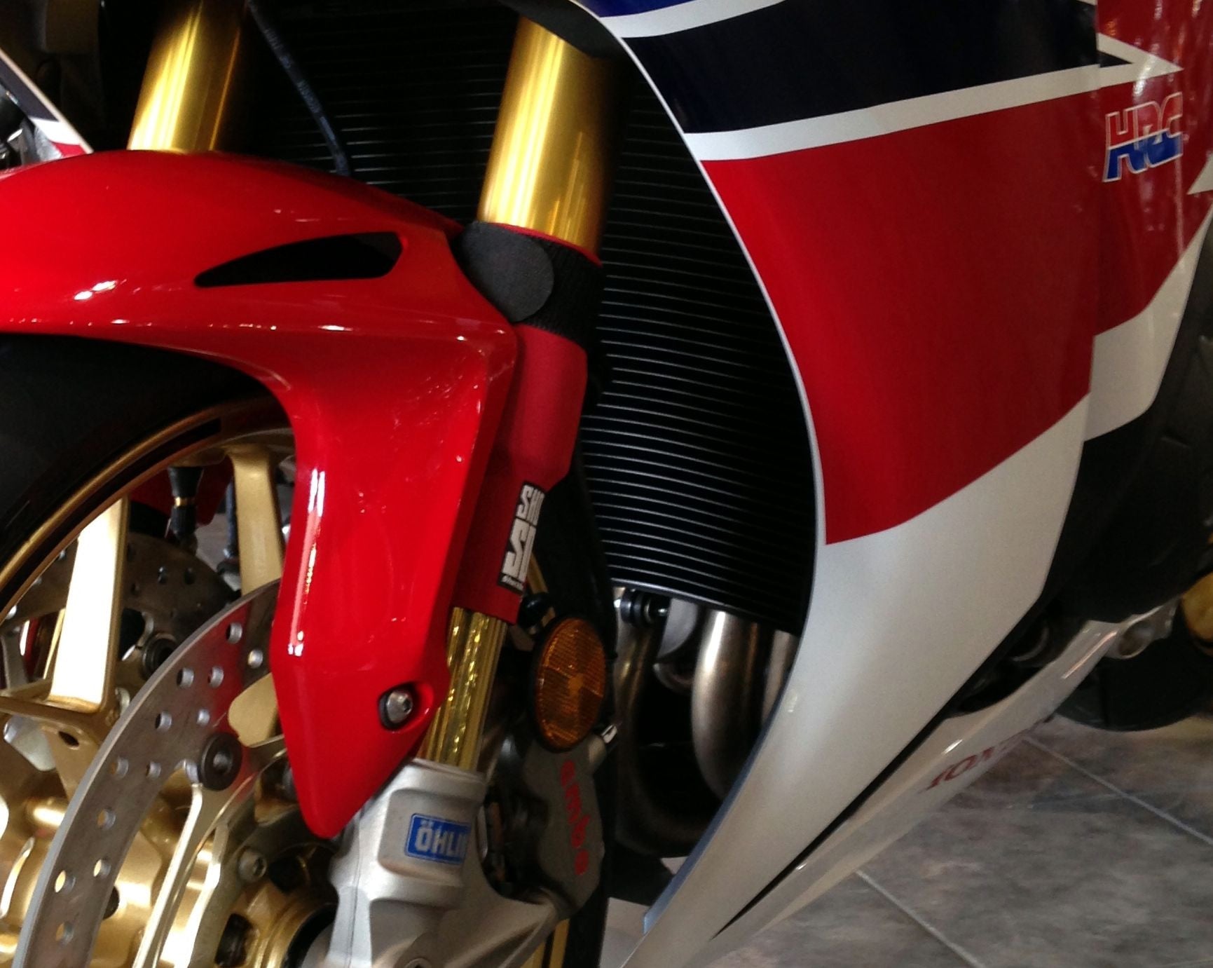 A closeup on red Shock Sox on a street bike.