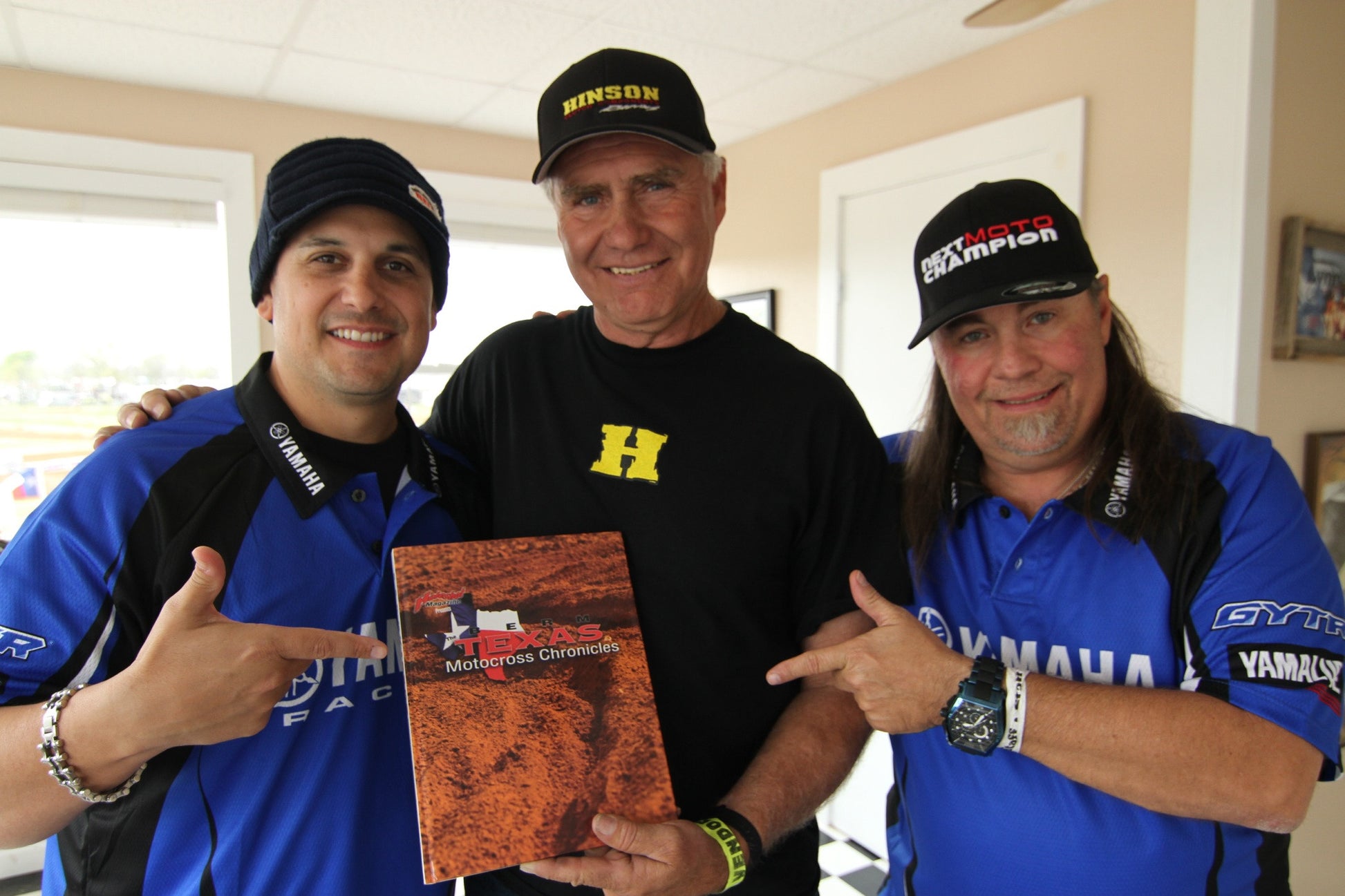A group of people standing and holding the BERM book.